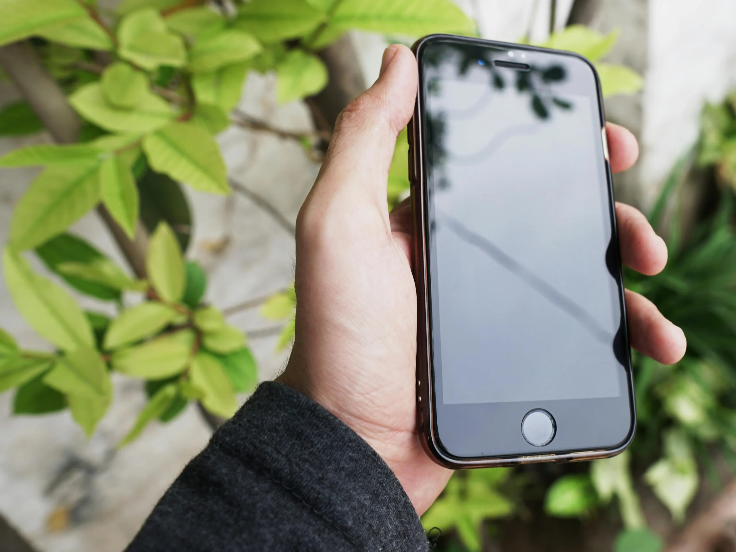 iOS 26.5 is now available for iPhone 11 and later iPhone in hand showing home screen, iOS 26.5 update available
